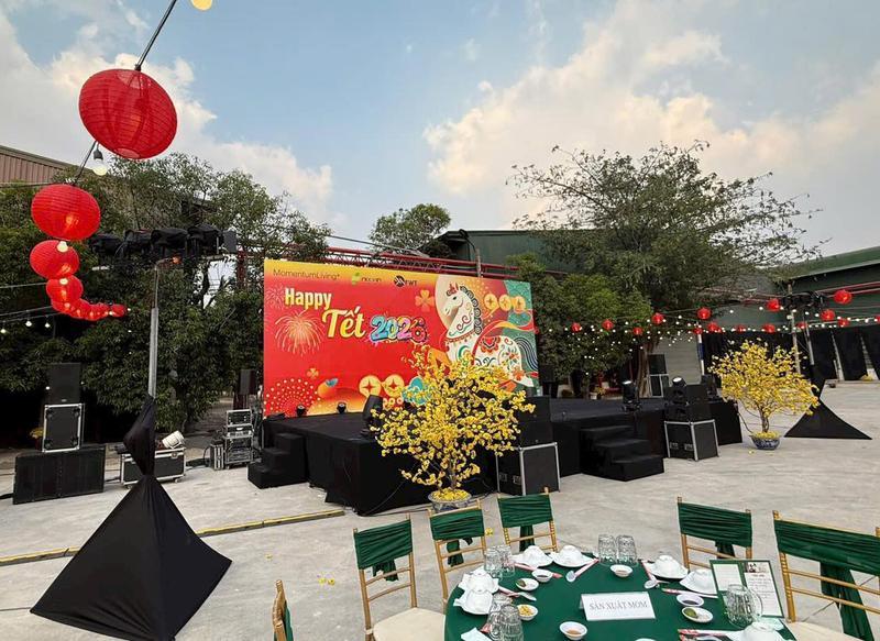 Sân khấu sự kiện Tết 2023 với hệ thống âm thanh ánh sáng và trang trí đèn lồng đỏ cùng bàn tiệc ngoài trời