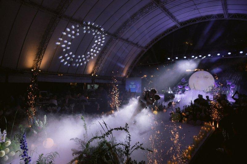 Màn trình diễn ánh sáng và khói nghệ thuật trong một sự kiện trong nhà với sân khấu và khách mời