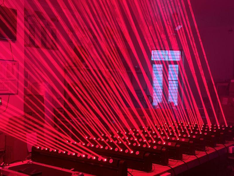 Dàn đèn chiếu sáng phát ra tia laser đỏ được sắp xếp đồng đều trong không gian trong nhà