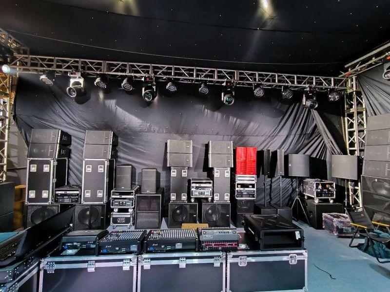 Dàn thiết bị âm thanh ánh sáng chuyên nghiệp được bố trí trong không gian sự kiện, bao gồm loa, mixer và đèn chiếu sáng