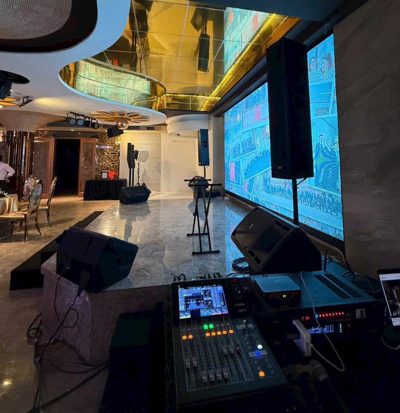 Hệ thống âm thanh và ánh sáng sự kiện được thiết lập trên sân khấu trong hội trường sang trọng