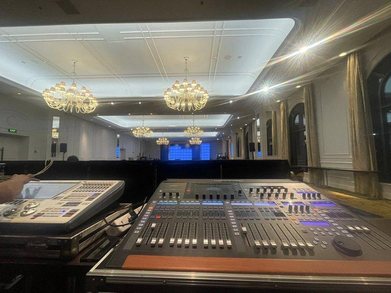 Bàn điều khiển âm thanh và ánh sáng tại phòng sự kiện sang trọng với nhiều đèn chùm