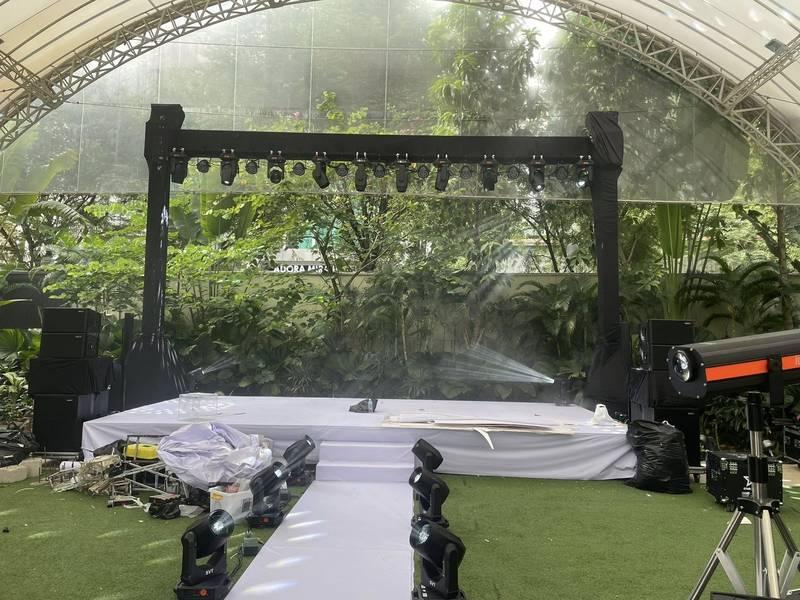 Sân khấu ngoài trời với hệ thống đèn chiếu sáng và âm thanh đang được lắp đặt