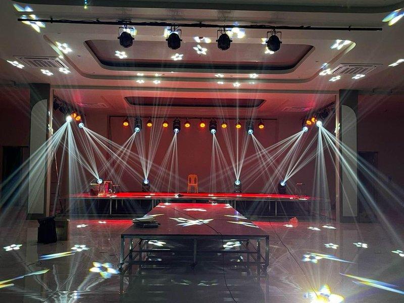 Hệ thống đèn chiếu sáng sân khấu hiện đại với hiệu ứng ánh sáng hoa trên nền sàn trống cho sự kiện