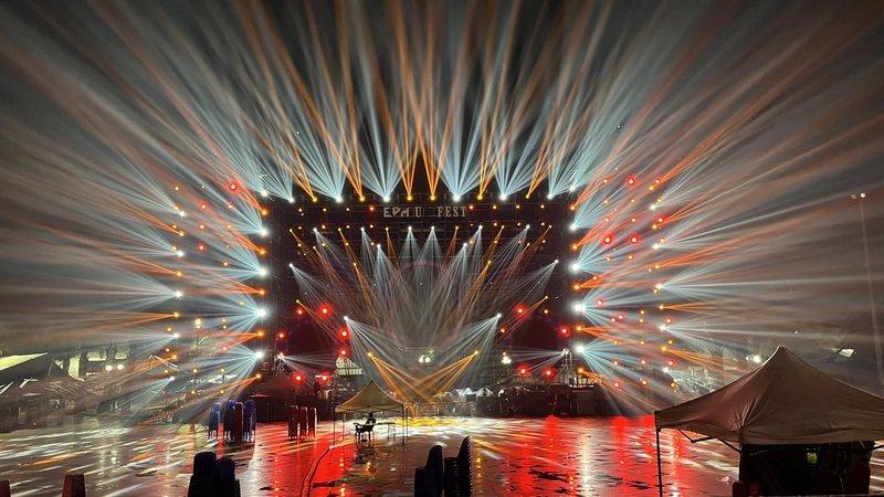 Hệ thống ánh sáng sân khấu chuyên nghiệp với nhiều đèn pha và hiệu ứng chiếu sáng rực rỡ trong một sự kiện âm nhạc