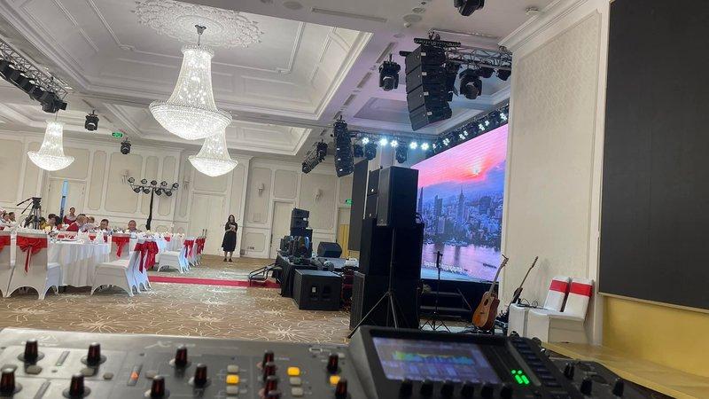 Hệ thống âm thanh ánh sáng chuyên nghiệp được setup trong hội trường tổ chức sự kiện với bàn mixer và màn hình LED lớn