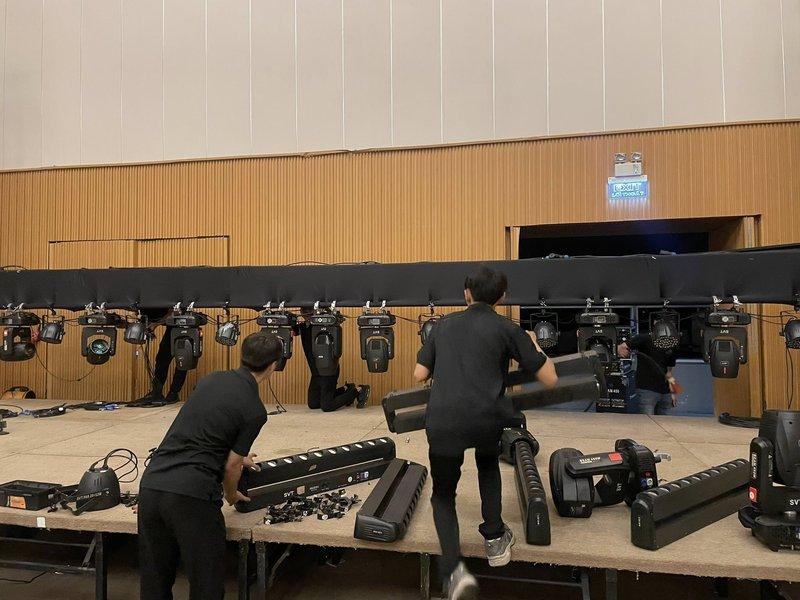 Nhân viên kỹ thuật lắp đặt hệ thống ánh sáng sân khấu cho sự kiện trong nhà