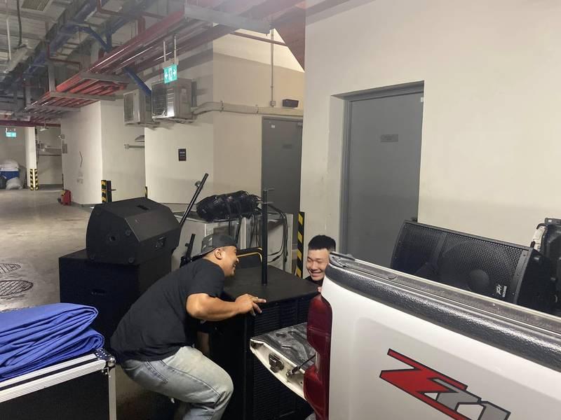 Hai người đang vận chuyển loa sự kiện vào xe tải trong dịch vụ cho thuê âm thanh sự kiện - loa sân khấu trọn gói HCM.