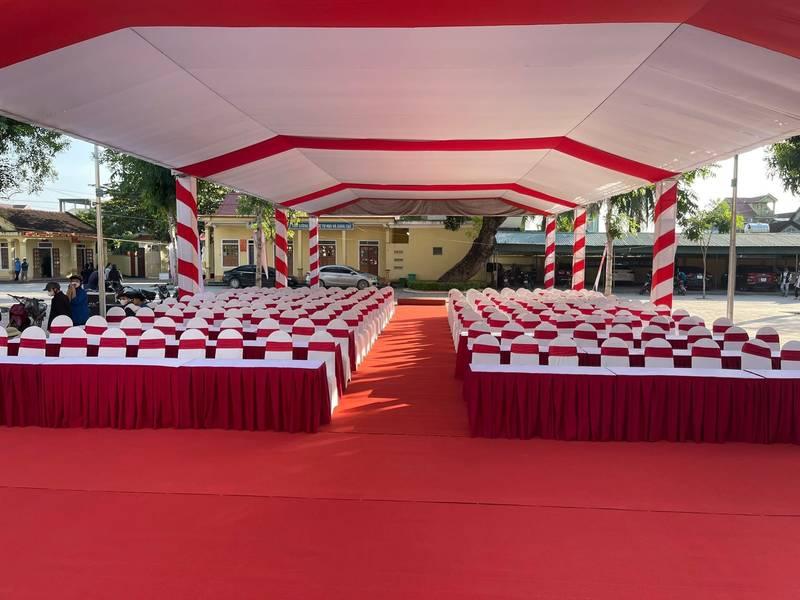 Cho thuê bàn ghế sự kiện giá rẻ tại TP.HCM với mẫu ghế trắng đỏ sang trọng dưới mái che rộng.