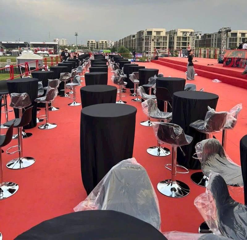 Cho thuê bàn ghế sự kiện giá rẻ tại TP.HCM với bàn tròn và ghế cao hiện đại trên nền thảm đỏ.