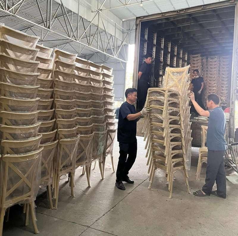 Cho thuê bàn ghế sự kiện giá rẻ tại TP.HCM với đội ngũ bốc xếp đang vận chuyển ghế trong kho.