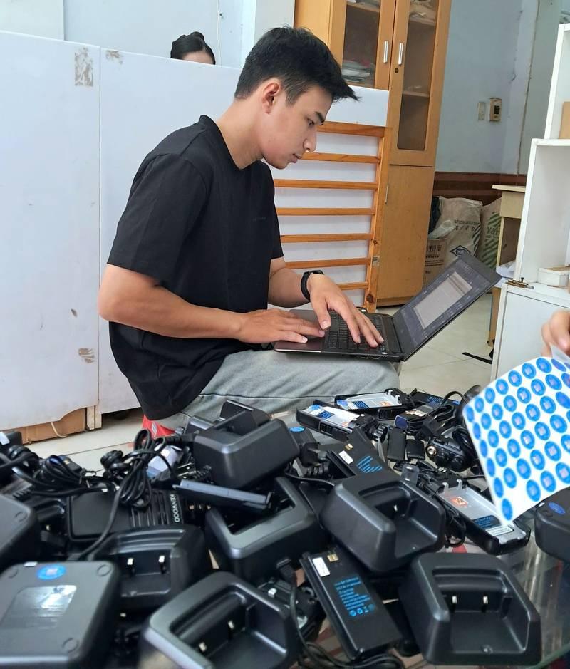 Nam nhân viên kiểm tra bộ đàm chuẩn bị cho thuê bộ đàm sự kiện giá rẻ, chuyên nghiệp HCM.