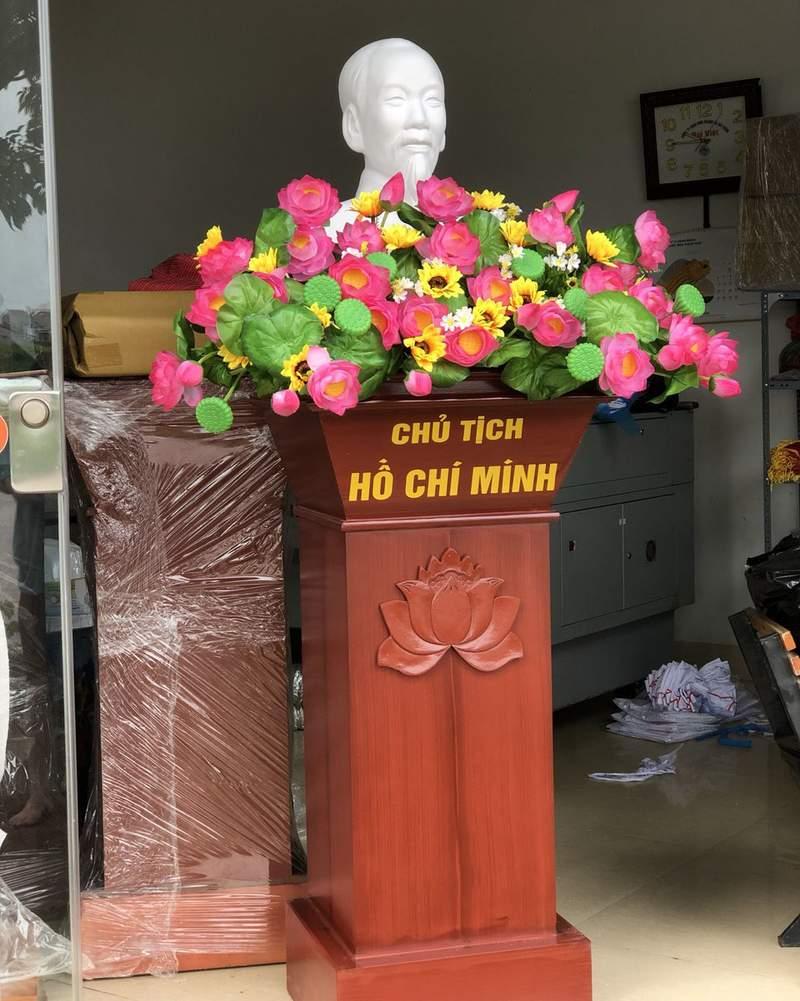 Cho thuê bục phát biểu gỗ đẹp đa dạng mẫu tại HCM với hoa trang trí và tượng Chủ tịch Hồ Chí Minh.