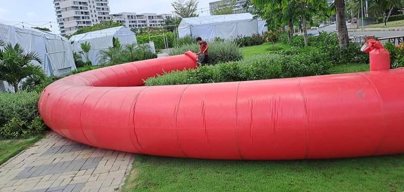 ALT: Cho thuê cổng hơi sự kiện giá rẻ, trọn gói tại TPHCM với cổng hơi màu đỏ đang được chuẩn bị lắp đặt trong khu vực ngoài trời.