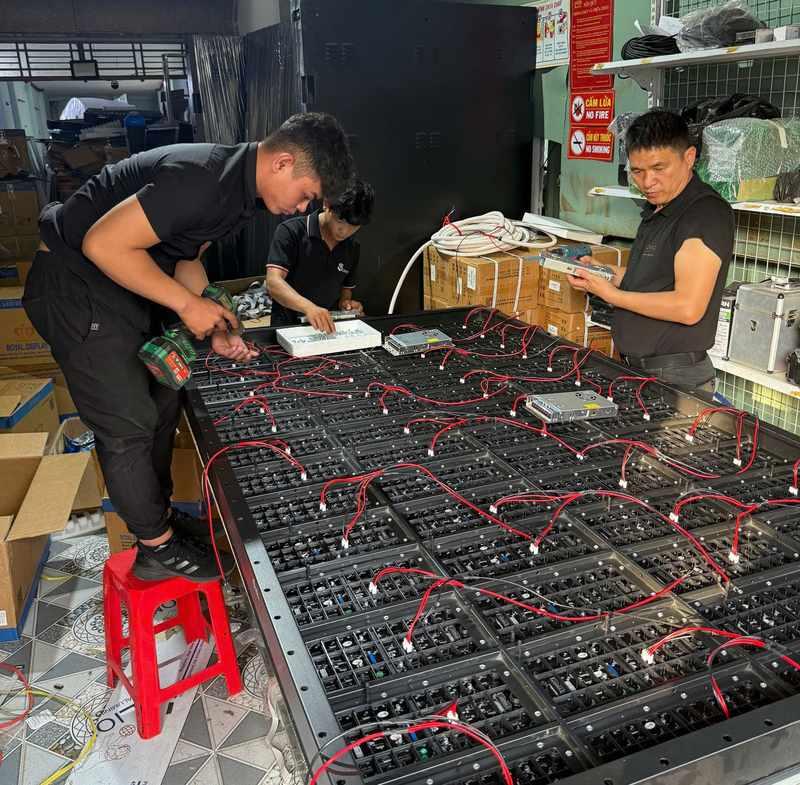 3 kỹ thuật viên đang thi công nhanh cho thuê màn hình led sự kiện HCM giá rẻ tại xưởng.