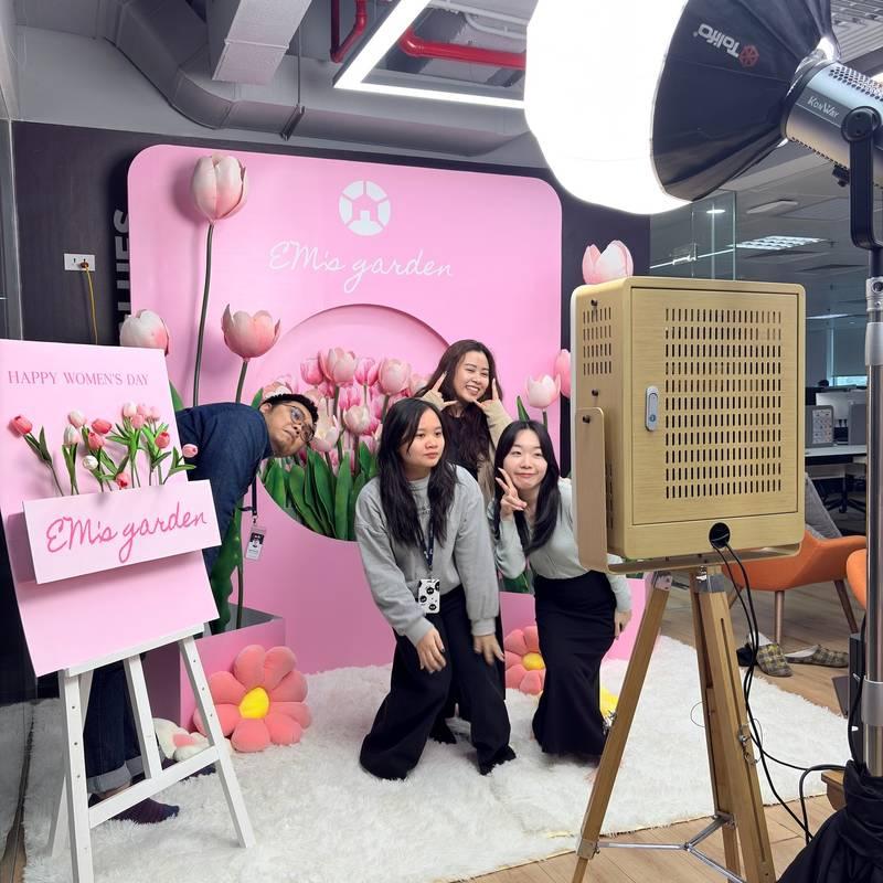 Cho thuê photobooth sự kiện trọn gói giá rẻ HCM với backdrop hoa tulip và nhóm bạn chụp hình vui vẻ.