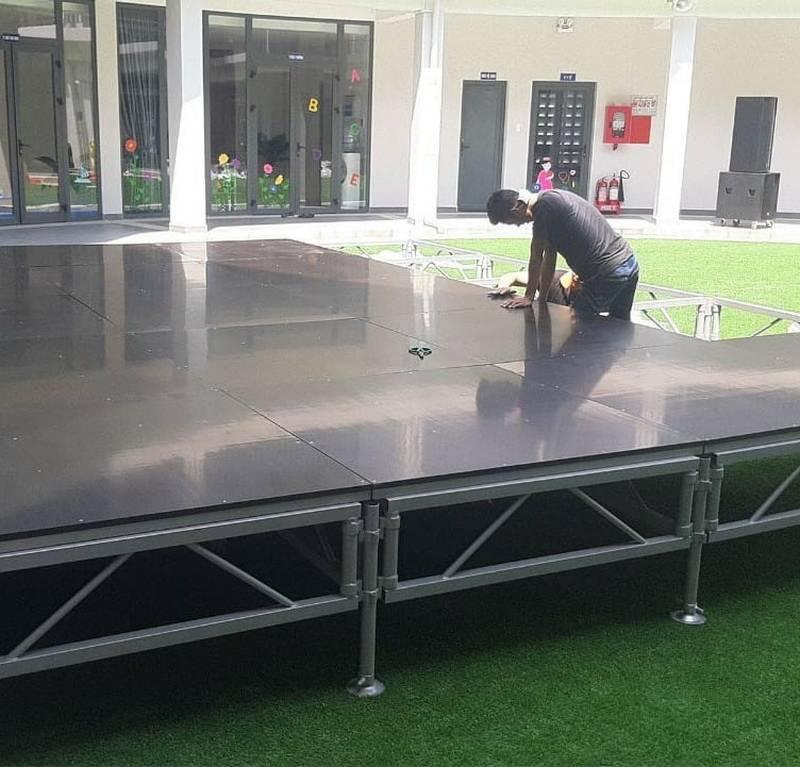 Nam công nhân đang lắp đặt sân khấu sự kiện cho thuê sân khấu sự kiện trọn gói giá rẻ HCM.