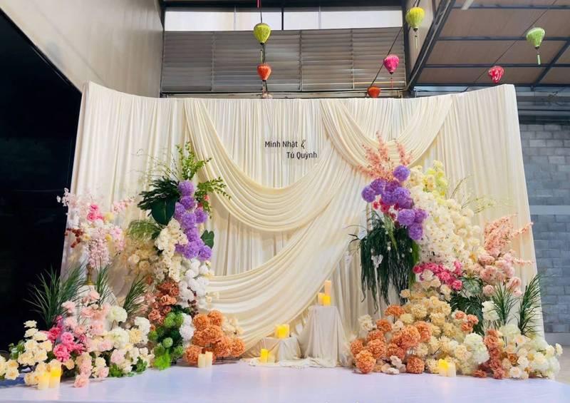 Cho thuê sân khấu sự kiện trọn gói giá rẻ HCM với backdrop hoa tươi và phông nền trắng sang trọng.