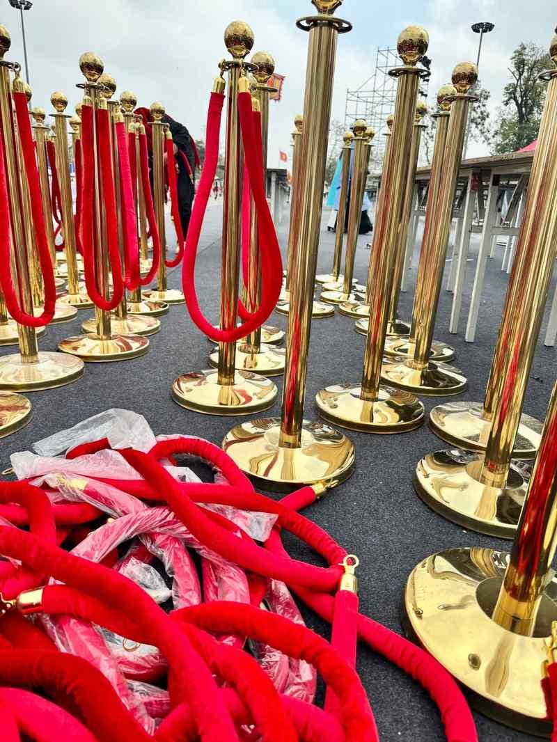 ALT ảnh: Cho thuê trụ barrier inox dây nhung giá rẻ HCM với các cột barrier mạ vàng và dây nhung đỏ.