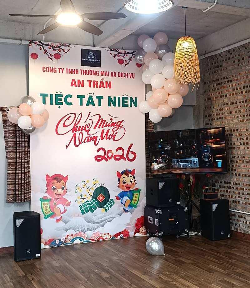 Không gian tổ chức tiệc tất niên với backdrop chúc mừng năm mới 2026 và hệ thống loa phục vụ, thể hiện Dịch vụ cho thuê loa kẹo kéo chuyên nghiệp