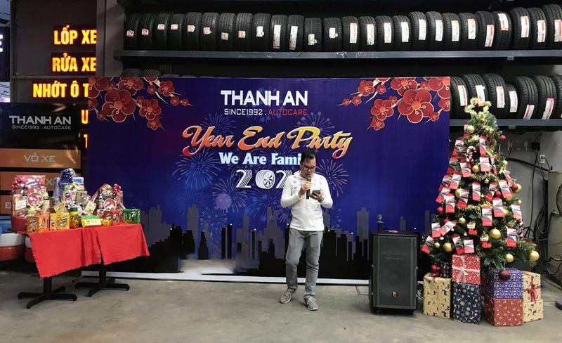 Người đàn ông đang nói chuyện qua micro tại bữa tiệc Year End Party 2021 trong gara ô tô có loa kẹo kéo, thể hiện Dịch vụ cho thuê loa kẹo kéo phục vụ sự kiện.