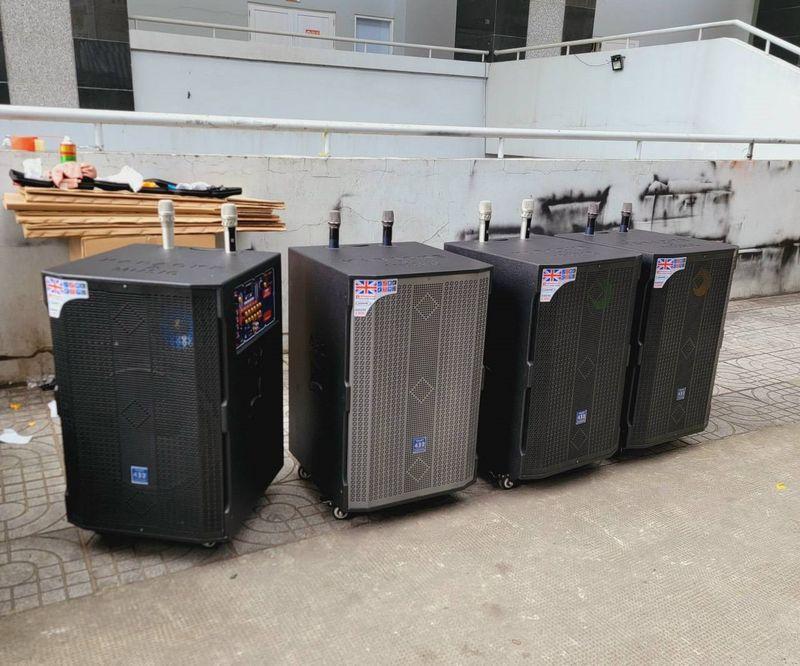 Dàn loa kẹo kéo đặt sát tường gồm bốn loa lớn với micro, thể hiện dịch vụ cho thuê loa kẹo kéo chất lượng cao.