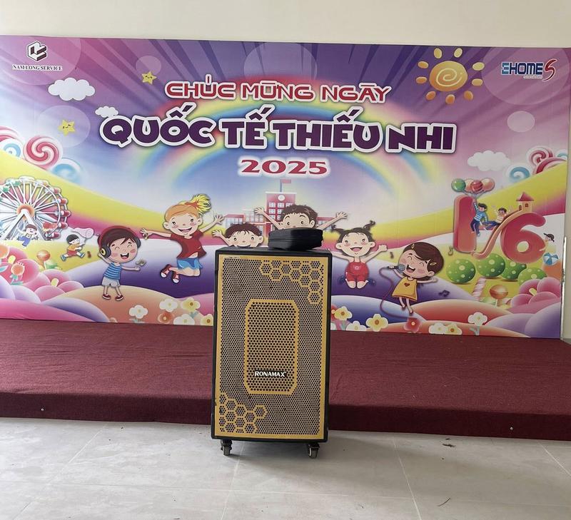 Loa kẹo kéo Ronamax đặt trước backdrop chúc mừng ngày Quốc tế Thiếu Nhi 2025 trong sự kiện dành cho trẻ em, thể hiện dịch vụ cho thuê loa kẹo kéo chất lượng