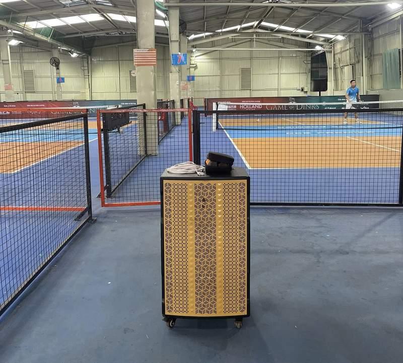  Loa kẹo kéo được đặt trong sân chơi cầu lông với người chơi đang thi đấu, thể hiện dịch vụ cho thuê loa kẹo kéo chất lượng.