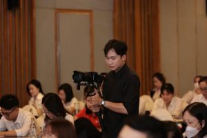Ekip chuyên nghiệp dùng dịch vụ quay phim chụp ảnh sự kiện trọn gói tại hội thảo đông người.