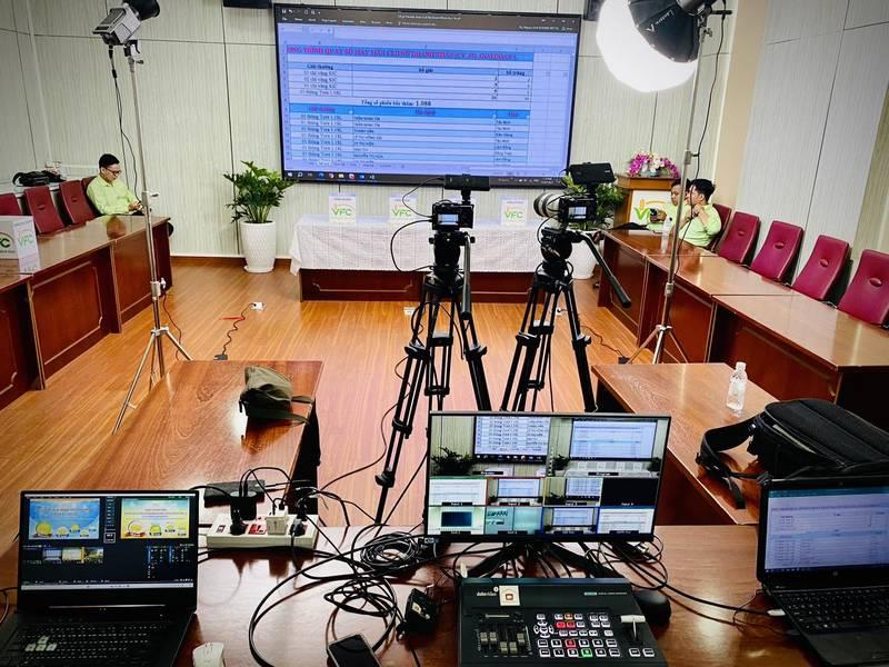 Dịch vụ quay phim chụp ảnh sự kiện trọn gói với ekip chuyên nghiệp đang setup thiết bị quay phim và máy tính trong phòng họp.