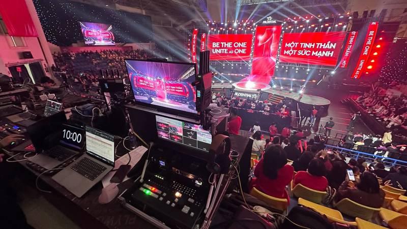 Dịch vụ quay phim chụp ảnh sự kiện trọn gói với ekip chuyên nghiệp thực hiện tại sân khấu lớn đầy ánh sáng và màn hình LED.