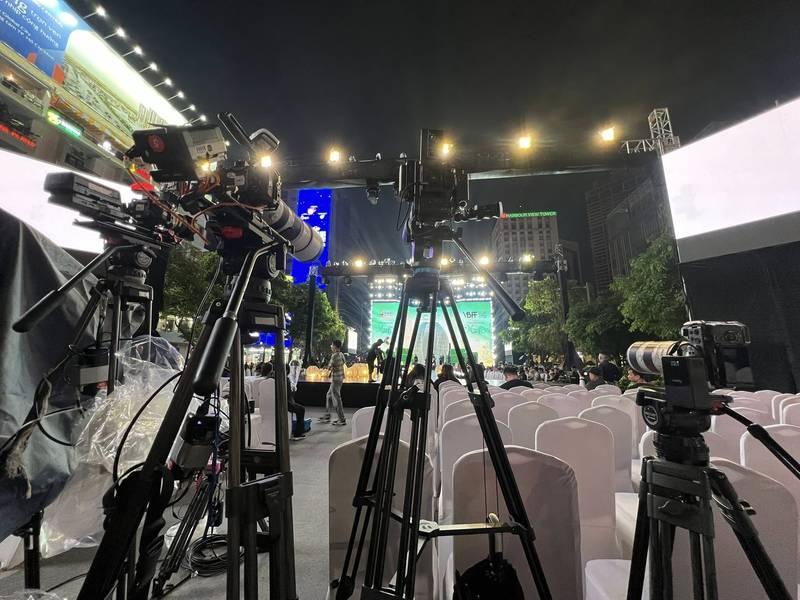 Ảnh chụp ekip chuyên nghiệp sử dụng dịch vụ quay phim chụp ảnh sự kiện trọn gói tại buổi lễ ngoài trời ban đêm.