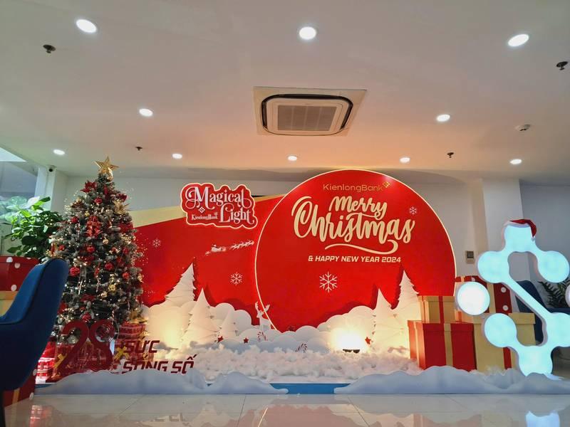ALT: Dịch vụ trang trí noel văn phòng trọn gói giá tốt HCM với cây thông và phông nền Merry Christmas 2024.