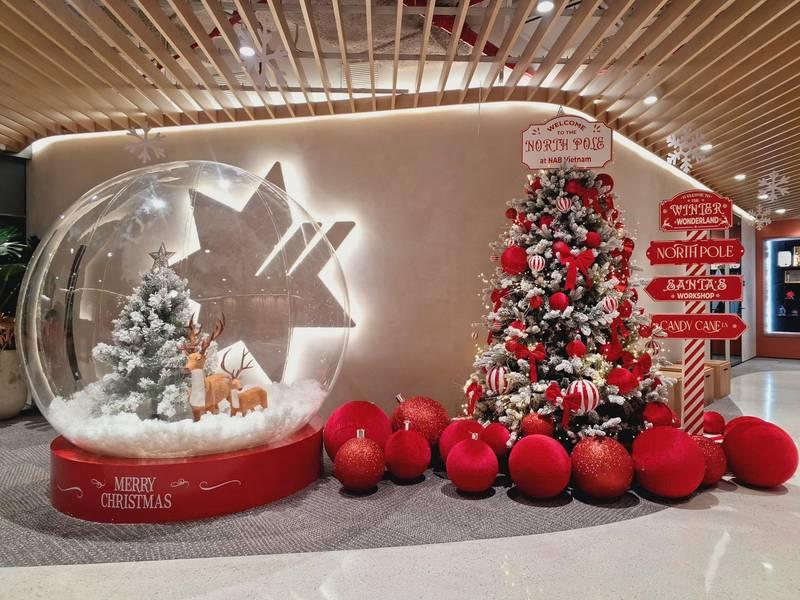 Dịch vụ trang trí noel văn phòng trọn gói giá tốt HCM với cây thông và quả cầu giáng sinh đỏ hiện đại.