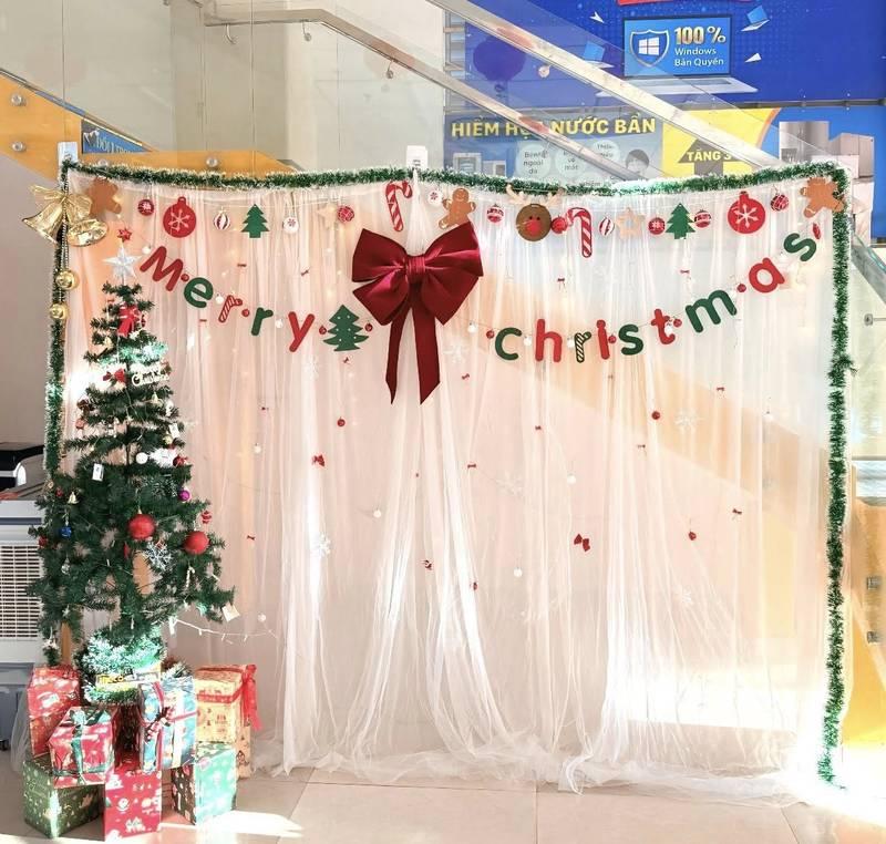 Ảnh trang trí noel với cây thông và background rèm trắng, phù hợp dịch vụ trang trí noel văn phòng trọn gói giá tốt HCM.