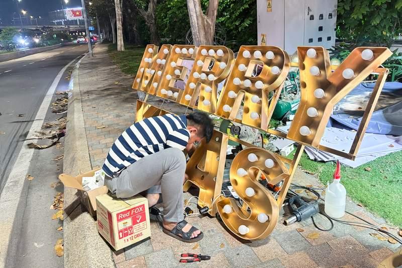 Nam công nhân lắp đặt biển chữ phát sáng MERRY CHRISTMAS phục vụ dịch vụ trang trí noel văn phòng trọn gói giá tốt HCM.