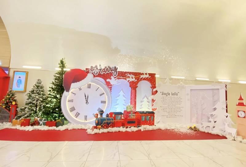 Dịch vụ trang trí noel văn phòng trọn gói giá tốt HCM với cảnh trang trí đồng hồ, xe lửa và cây thông Noel.