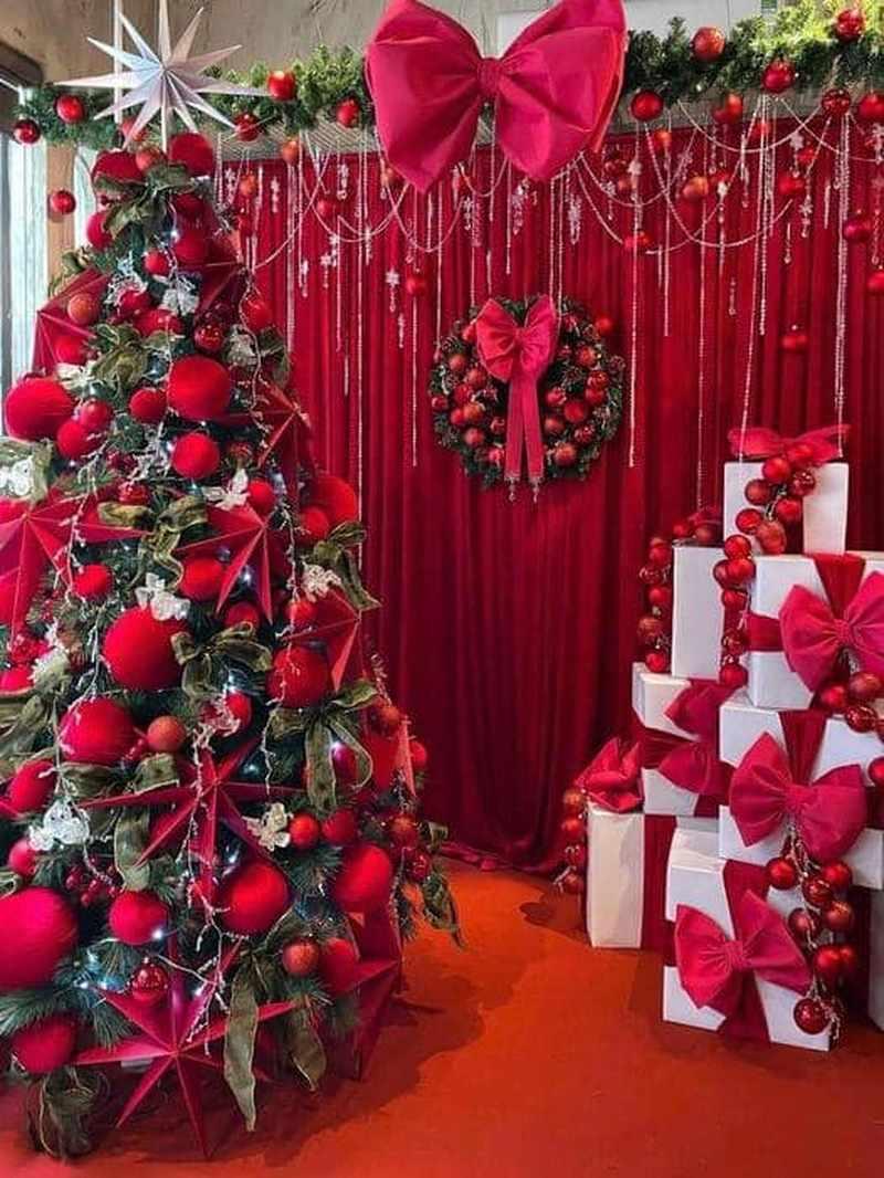 Dịch vụ trang trí noel văn phòng trọn gói giá tốt HCM với cây thông, vòng nguyệt quế và hộp quà tặng đỏ đậm.