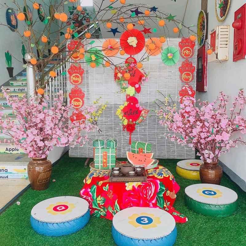 Dịch vụ trang trí Tết với tiểu cảnh trọn gói gồm bàn trà, quà Tết và hoa đào đẹp mắt.