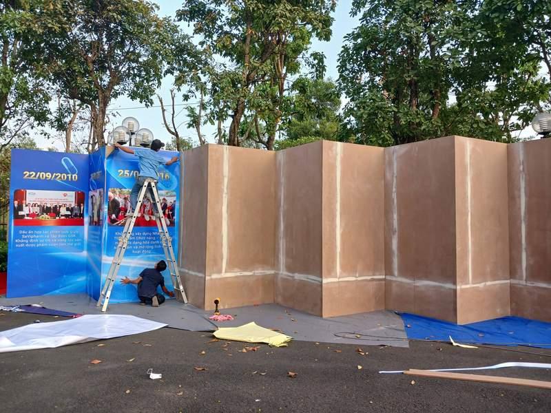Thi công booth sự kiện ngoài trời, đang lắp đặt bảng quảng cáo trong dự án thiết kế trọn gói giá tốt HCM.