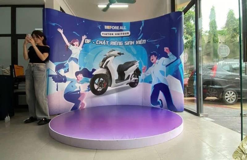 Thi công booth sự kiện thiết kế trọn gói giá tốt HCM với sân khấu tròn và phông nền quảng cáo xe máy điện.