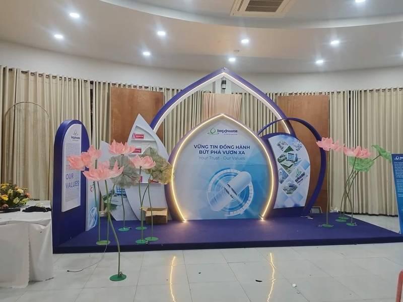 Thi công booth sự kiện kết hợp thiết kế trọn gói giá tốt HCM với khung ánh sáng và hoa giả trang trí sang trọng.