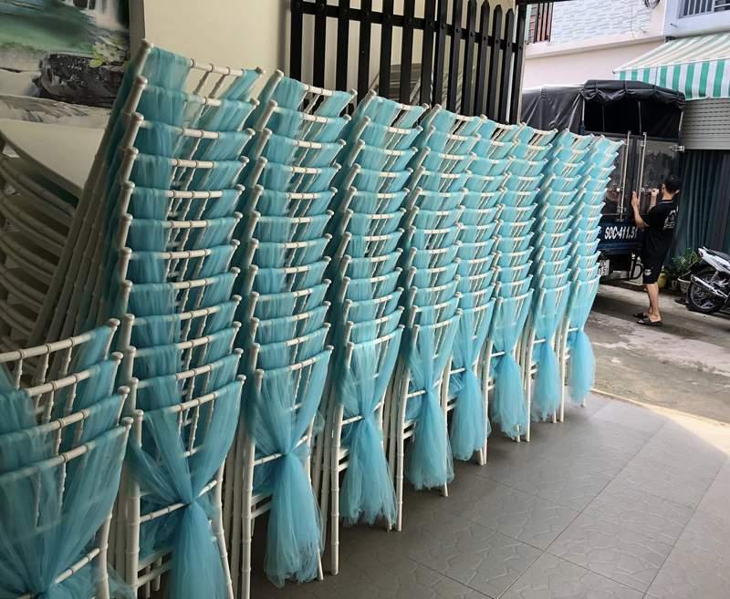 Hàng ghế Tiffany trắng được trang trí khăn voan xanh chuẩn bị cho thuê ghế Tiffany sự kiện trọn gói HCM.