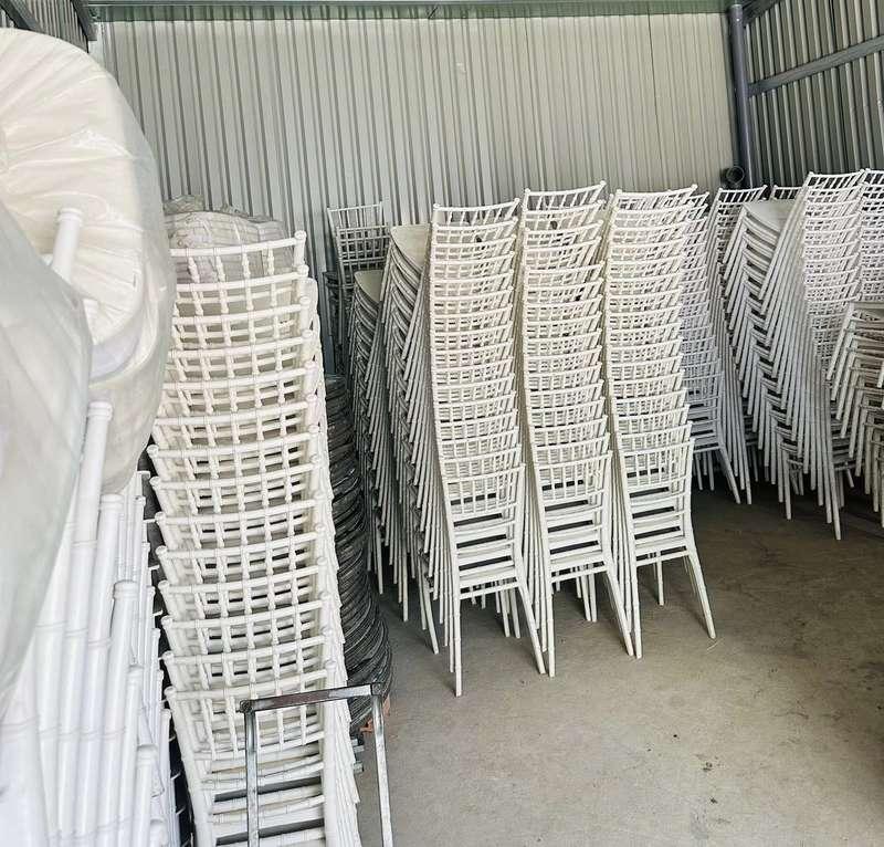 Kho chứa với nhiều bộ ghế trắng mang phong cách thuê ghế tiffany sự kiện cho thuê ghế Tiffany cho sự kiện trọn gói HCM.