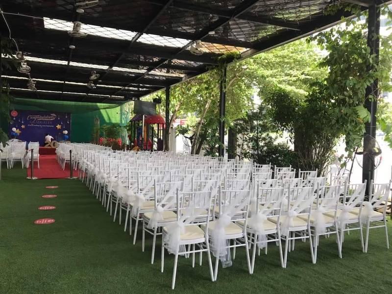 Ảnh sân khấu ngoài trời với dãy ghế trắng chuẩn bị cho thuê ghế Tiffany sự kiện trọn gói HCM.