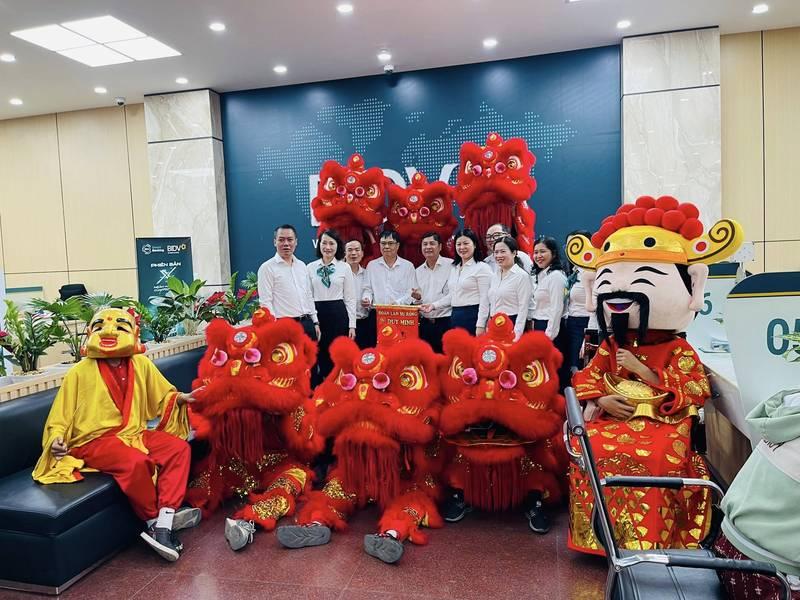 Đội hình thuê múa lân khai trương trọn gói giá rẻ HCM chụp hình cùng khách hàng trong sự kiện văn phòng.