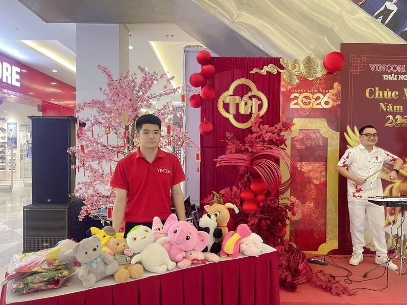 Nam nhân viên tại gian hàng với đồ chơi búp bê, trang trí Tết 2026 trong sự kiện tổ chức activation chuyên nghiệp của agency activation uy tín.