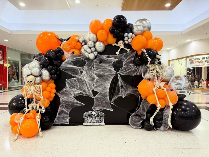 Trang trí với bóng bay cam đen, bộ xương và mạng nhện cho tổ chức sự kiện Halloween trọn gói HCM.