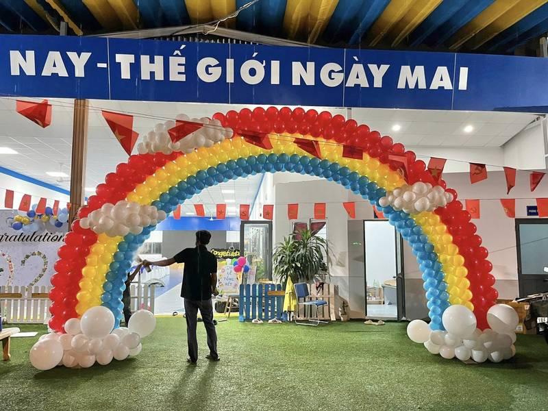 Trang trí bóng bay sự kiện tạo hình cầu vồng màu sắc rực rỡ trước sân khấu backdrop trọn gói.