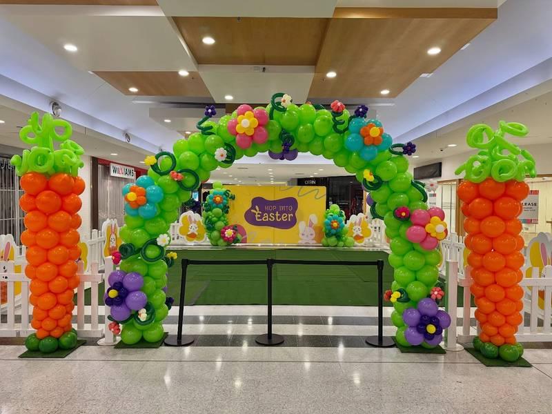 Ảnh trang trí bóng bay sự kiện với cổng bóng xanh lá kết hợp hoa nhiều màu, sân khấu và backdrop trọn gói chủ đề Easter.
